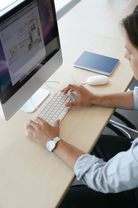 Jeune homme en costume assis devant un ordinateur de bureau