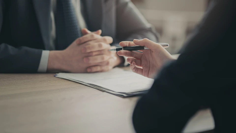 Deux professionnels collaborent dans un bureau moderne autour d'analyses commerciales